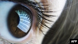 Монитор компьютера, отражающийся в глазах девушки.  