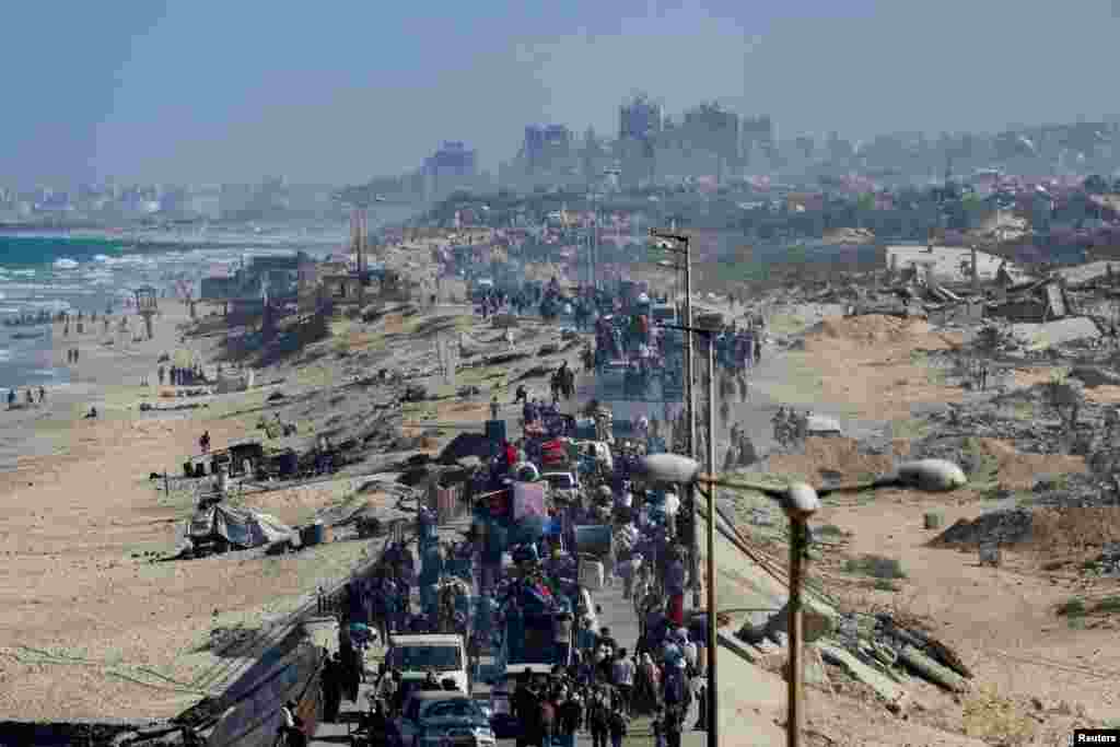 Палестинцы, которые были перемещены в южную часть Газы по приказу Израиля, идут по дороге, возвращаясь на север, на фоне прекращения огня между Израилем и ХАМАС в Газе, 11 октября 2025 года. REUTERS/Mahmoud 