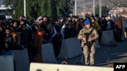 Sirieni așteptând la graniță să revină în țară la Cilvegozu, în Turcia, la 9 decembrie 2024. 