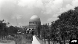 În 1967, un vehicul militar israelian se îndreaptă spre Domul Stâncii, cea mai veche construcție islamică funcțională din lume, lângă Moscheea Al-Aqsa. Locul (Haram ash Sharif / Muntele Templului) este unul sfânt și pentru musulmani și pentru evrei și creștini.