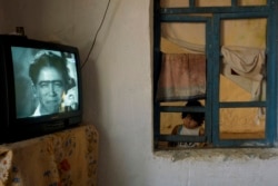 Бухарага жакын жердеги лөлү айылында сыналгы көрүп жаткан кыз.