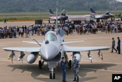 Personal militar chinez lângă un avion de vânătoare J-10C în timpul celei de-a 13-a Expoziții Internaționale de Aviație și Aerospațială din China, cunoscută și sub numele de Airshow China, în septembrie 2021.