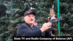 Fostul șef de colhoz, Alexandr Lukașenko, într-o demonstrație de forță făcută pentru intimidarea protestatarilor care au ieșit în stradă pentru a contesta victoria sa la alegerile din 9 august 2020. Înarmat cu un Kalașnikov, în grădina palatului de la Minsk, 23 august 2020.