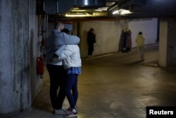 Люди ховаються на підземного паркінгу під час ракетно-дронової атаки на Київ, 14 листопада 2025 року