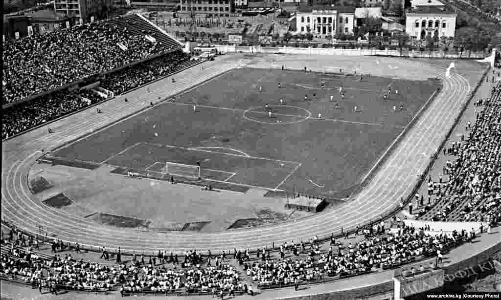 "Алга" жана "Уралмаш" футбол клубдарынын беттеши. 1964-жыл. Фрунзе шаарындагы Спартак стадион. Бул стадион 1939-жылы курулуп баштап, 1941-жылы ишке кирген. Аталган стадиондо Фрунзе шаарынын футбол клубдары беттештерди өткөрүп келген. Азыр бул стадион Кыргыз ССРнин биринчи спорт комитетинин жетекчиси Дөлөн Өмүрзаковдун атын алып жүрөт. Мында "ак шумкарлар" расмий беттештерин өткөрүп келет.&nbsp;