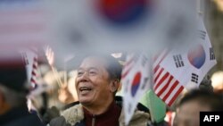 La Seul au avut loc și demonstrații de sprijin pentru președintele Yoon, organizate de partidul său conservator. Oamenii au venit cu drapele coreene, dar și americane - conservatorii sunt principalii susținători ai alianței SUA-Coreea de Sud.