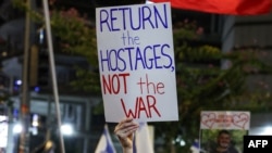 Un manifestant ține o pancartă în timpul unui protest care solicită luarea de măsuri pentru eliberarea ostaticilor rămași captivi în Gaza de la atacurile 2023 din 7 octombrie ale militanților palestinieni