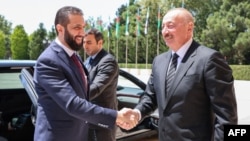 This handout picture released by the Syrian Presidency shows Azerbaijan's President Ilham Aliyev (right) receiving Syria's interim President Ahmed al-Sharaa in Baku on July 12.
