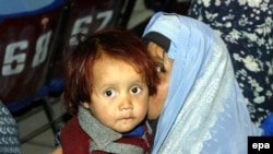 O femeie și copilul ei la seminarul pe tema violenței domestice la Herat, în noiembrie 2009.