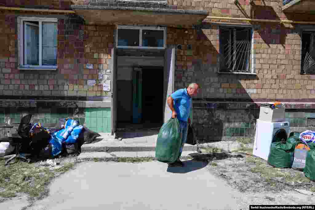 Місцеві жителі забирають з поруйнованих квартир вціліле майно, у цьому їм допомагають рятувальники. Київ, 29 серпня 2025 року