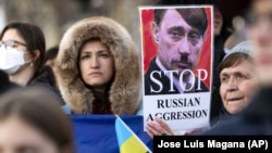 Участники акции против действий президента России Владимира Путина с призывом не вторгаться в Украину.