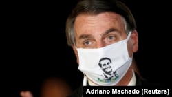 Președintele Braziliei Jair Bolsonaro purtând o mască cu propria sa imagine.