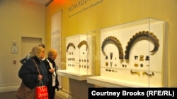 Бейитте ак сөөктөр менен кошо көмүлгөн текенин мүйүзү жана ат жабдуунун коло бөлүктөрү. Нью-Йорктогу байыркы дүйнөнү изилдөө институнун көргөзмө залы.