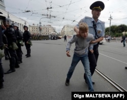 A young boy is led away by police in St. Petersburg on September 9.