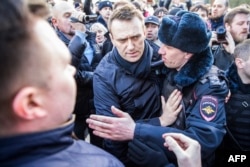 Poliția îl reține pe criticul Kremlinului Aleksei Navalny (centru) în timpul unui miting anti-corupție în centrul Moscovei, la 26 martie 2017.