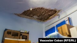 Tavan cu porțiuni lipsă într-un fost salon, transformat în depozit.