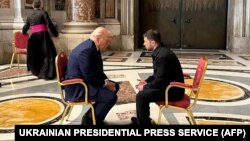 Прэзыдэнт Украіны Ўладзімір Зяленскі размаўляе з прэзыдэнтам ЗША Дональдам Трампам у кулюарах пахаваньня папы Францішка ў саборы Сьвятога Пятра ў Ватыкане. Фота зробленае і апублікаванае прэс-службай прэзыдэнта Ўкраіны, 26 красавіка 2025 году