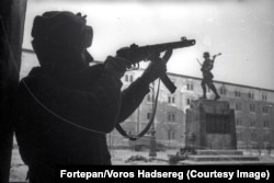 Un soldat sovietic fotografiat lângă un monument al unei unități militare maghiare.