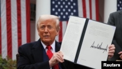 Donald Trump a büntetővámok bevezetéséről rendelkező elnöki rendelettel a kezében április 2-án