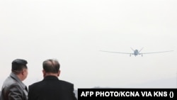 Kim Jong Un watching a drone at an undisclosed location in North Korea.