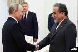 Președintele rus Vladimir Putin (stânga) și ministrul iranian de externe Abbas Araqchi, în timpul unei întâlniri la Kremlin, Moscova, pe 23 iunie 2025.
