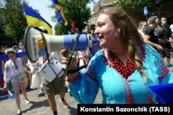 Наліпка «Мова об’єднує» на мегафоні учасниці мегамаршу у вишиванках в Одесі, 26 червня 2021 року