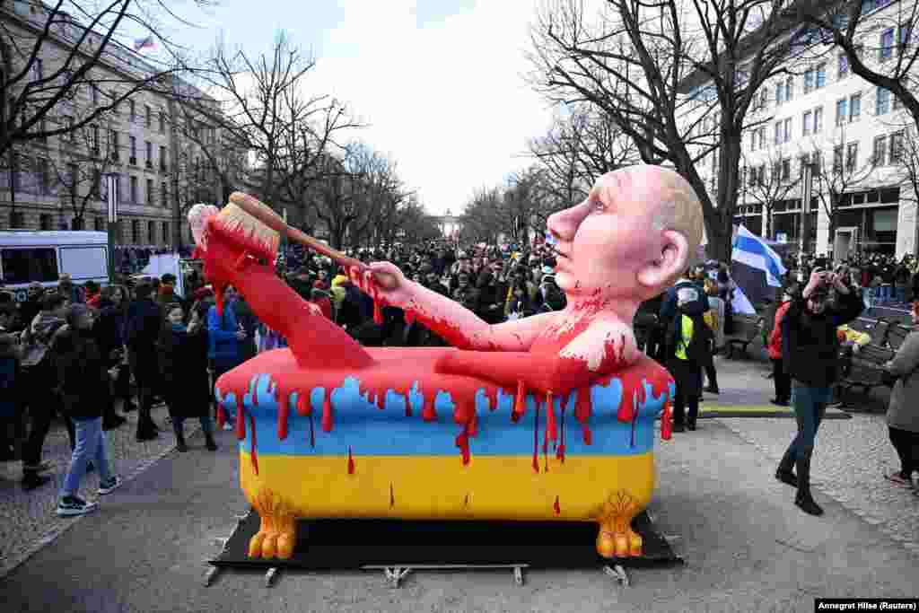 პუტინის გამოსახულება, რომელიც უკრაინელების სისხლში ბანაობს ბერლინში, რუსეთის საელჩოს წინ, 2024 წლის მარტი, რუსეთში საპრეზიდენტო არჩევნების ბოლო დღეს.