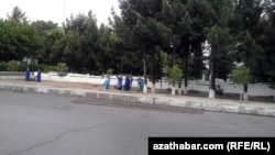 Türkmenistanyň Jemagat hojalygy ministrligine degişli edaralaryň işgärleri, şol sanda aýal-gyzlar ýagyşdan soň köçeleri arassalaýar. 15-nji maý, 2019 ý.