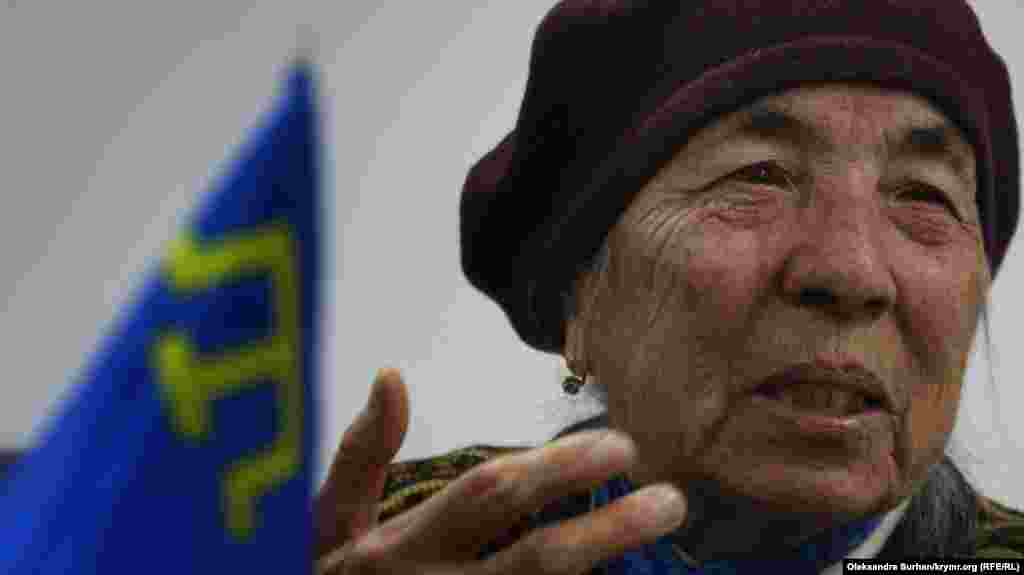 2019 senesi dekabr ayı. Qırımtatar bayrağı qırımtatar milily areketiniñ iştirakçisi Ayşe Seitmuratova yanında masa üstünde&nbsp;