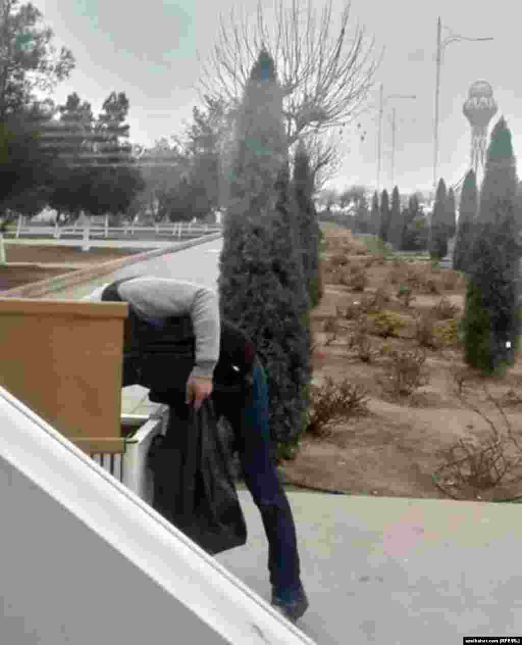 Молодой человек извлекает содержимое мусорного ящика, Ашхабад, январь, 2020