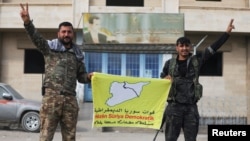 Membri ai formațiunii conduse de kurzi Forțele Democratice Siriene (SDF) cu steagul lor la Deir al-Zor, în estul Siriei, la 7 decembrie 2024.