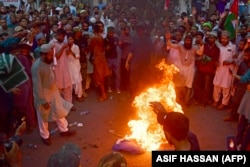 Kəraçidə İsrail əleyhinə aksiya zamanı etirazçılar İsrail bayrağını yandırırlar.