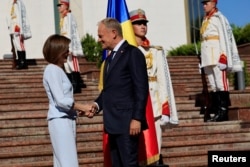 Președinta Republicii Moldova, Maia Sandu, dă mâna cu premierul Poloniei, Donald Tusk, la sosirea acestuia la Palatul Prezidențial din Chișinău, pe 27 august 2025.