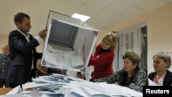Central Election Commission staff empty a ballot box after voting closed at a polling station in the South Ossetian city of Tskhinvali on November 13.