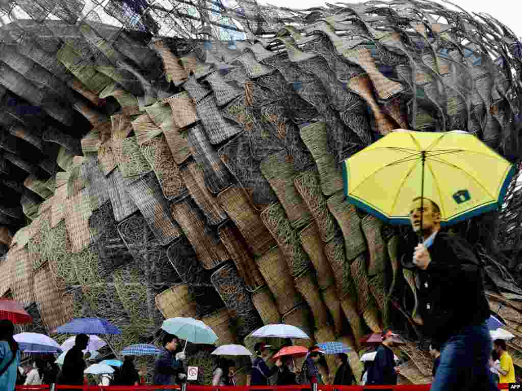 Мужчина спешит мимо испанского павильона на выставке ЭКСПО в Пекине