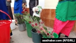 Продажа цветов в Ашхабаде. Одна из связок роз упакована в газеты с портретом президента Сердара Бердымухамедова  