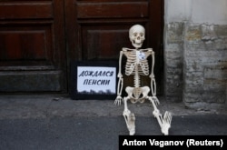 "Waited for pension": A model skeleton lies on the ground during a protest against the government's plan to raise the pension age in St. Petersburg on July 19.