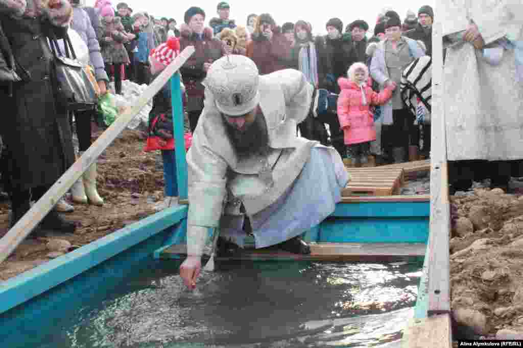 Епископ освящает воду.