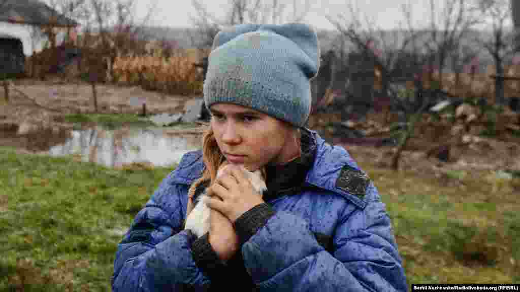 11-гадовая Сафійка абдымае сваю марскую сьвінку Пэпу падчас эвакуацыі зь сяла Макіеўка, Луганская вобласьць, лістапад 2022 году