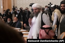 Бывший президент Афганистана Хамид Карзай (второй слева) смотрит, как члены делегации "Талибана" прибывают для участия в международной мирной конференции в Москве, 18 марта 2021 года.
