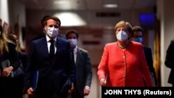 Cancelarul Angela Merkel și președintele Franței, Emmanuel Macron, îndreptându-se spre conferința de presă de la finalul summit-ului UE 