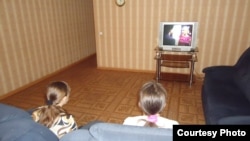 Пострадавшие от бытового насилия женщины смотрят телевизор в кризисном центре. Караганда, 7 июня 2013 года.
