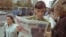 A military cadet pauses to read newspaper coverage of the presidential election at a kiosk in downtown Minsk.