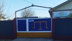 Decorating a fence in blue and yellow colors in a private house in the village of Urozhainoe, Sovetsky district, during the full-scale invasion of the Russian Federation into Ukraine, April 2025