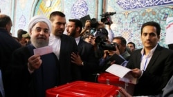 Iran's interior minister said President Hassan Rohani -- seen casting his ballot on May 19 -- won reelection with around 57 percent of the vote, easily avoiding a runoff. 