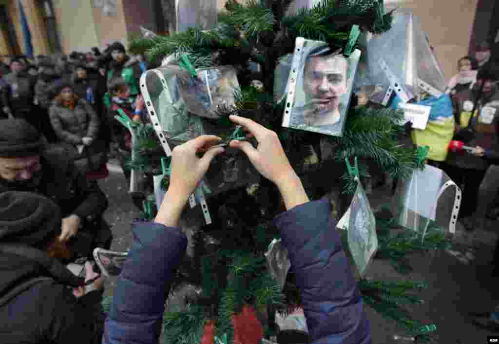 Киев. Участники Евромайдана украшают новогоднюю елку портретами жертв разгона акции сторонников евроинтеграции бойцами "Беркута".