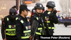 Китайские полицейские на улице в городе в Синьцзяне. 24 марта 2017 года. Иллюстративное фото.