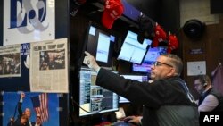 Brokeri la bursa de valori de la New York (NYSE) la deschiderea tranzacțiilor, pe 15 iulie 2025. Tarifele lui Trump domină scena. 