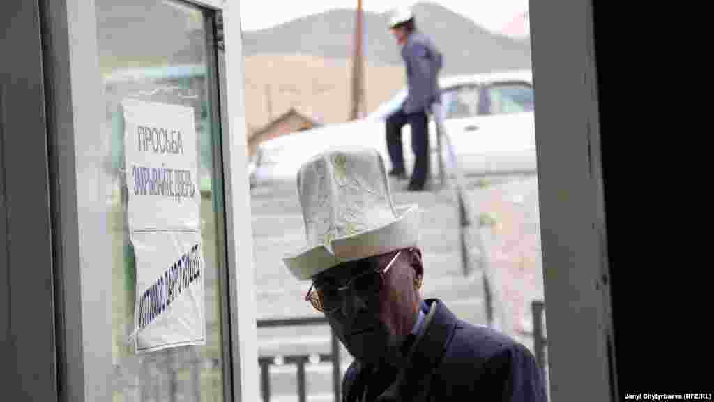 Сүрөттө: Мургабдын тургуну жергиликтүү өкмөттүк кеңсеге кирип келатат. Эшиктин айнегинде жазуулар орус жана тажик тилинде жазылган. Мургабда 1998-жылга чейин бардык жазуулар кыргызча болгон. Aзыр андай жазуулар шаарда дээрлик жок калган.