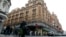 Пешеходы идут по улице рядом с дорогим лондонским магазином Harrods.